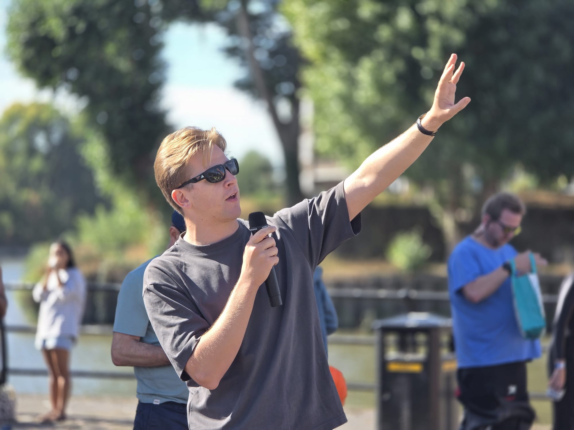 The compere on the microphone welcoming swimmers by the river
