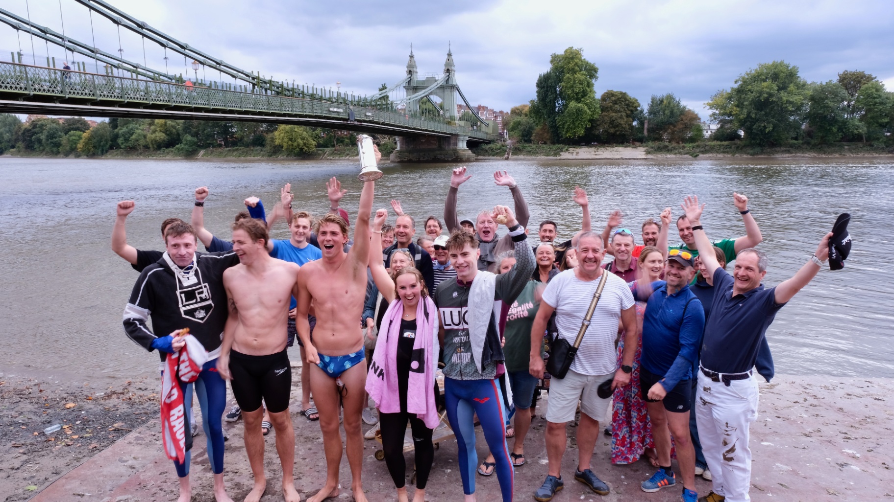 A group of swimmers smiling together after a river session