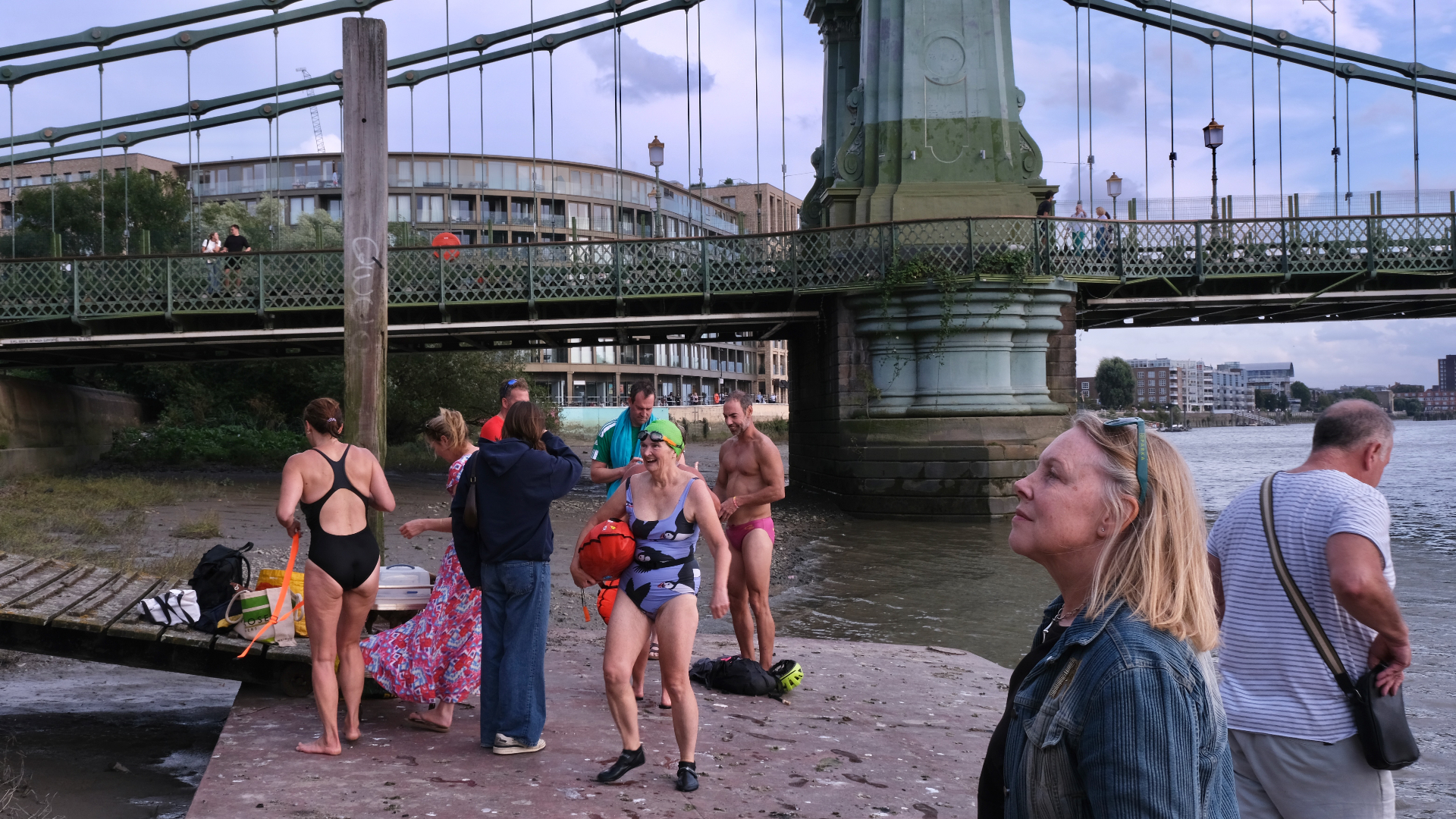 Swimmers gathering beneath Hammersmith Bridge by the Thames