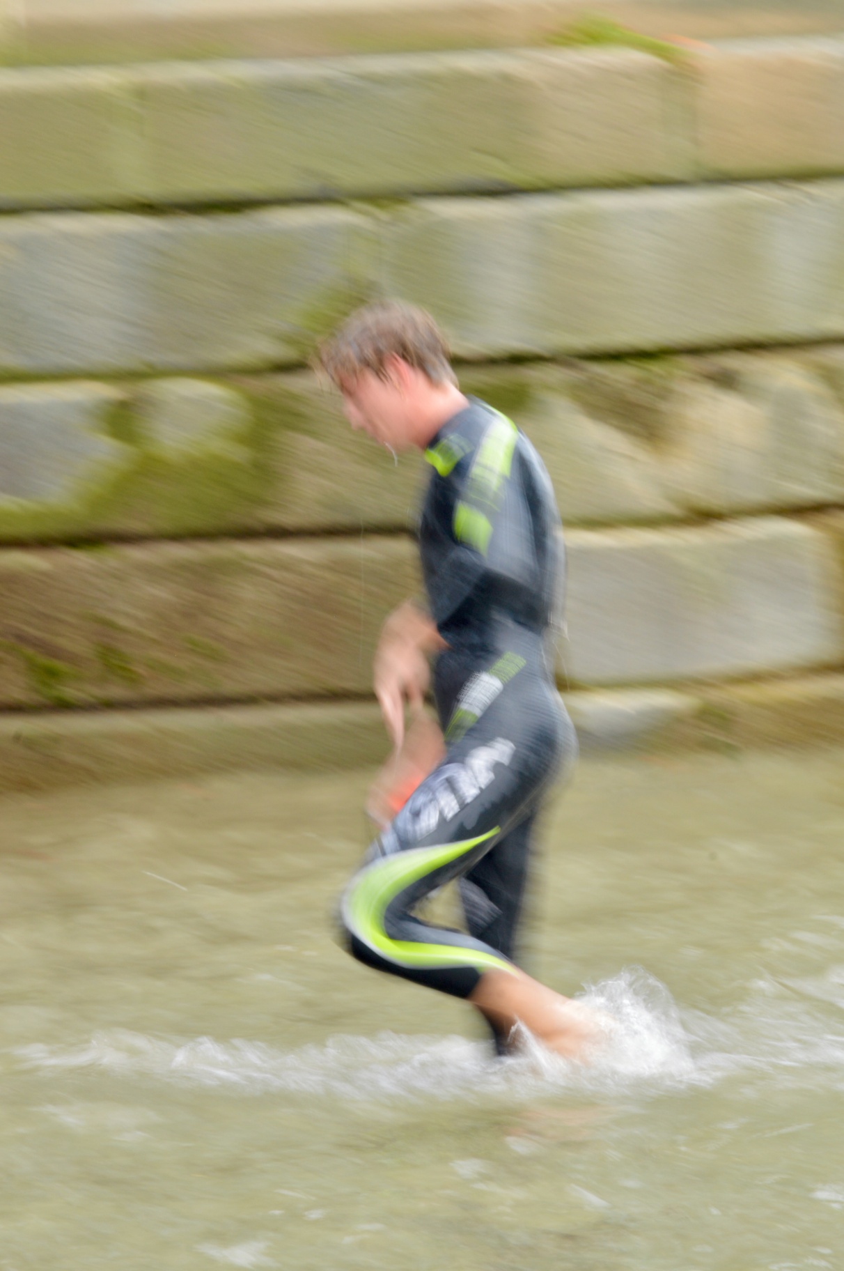 A swimmer emerging from the water at the river edge