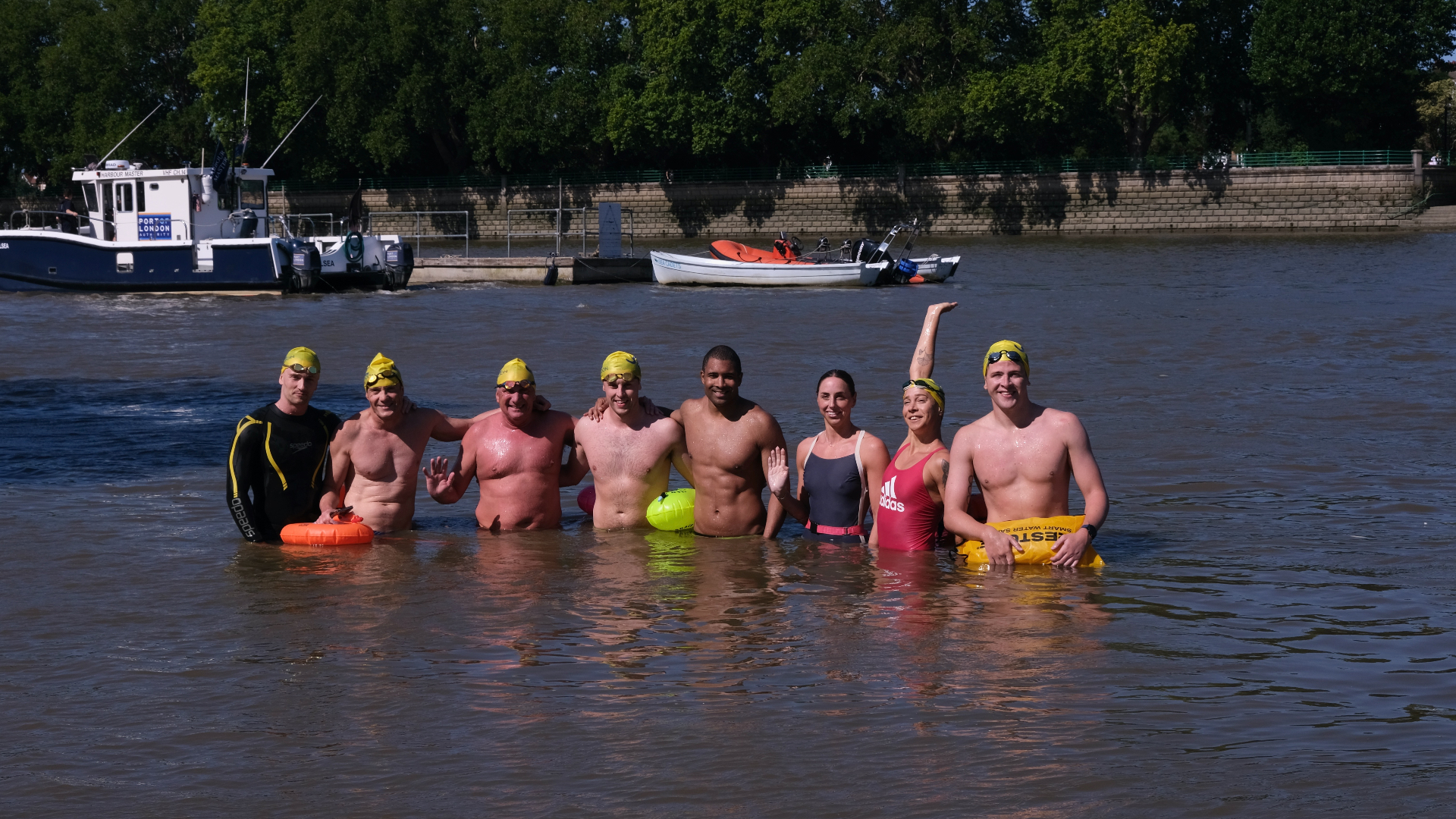 A group of swimmers celebrating together in the Thames